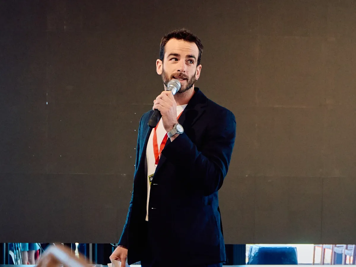 Luis Gustems presentando un evento con micrófono en mano