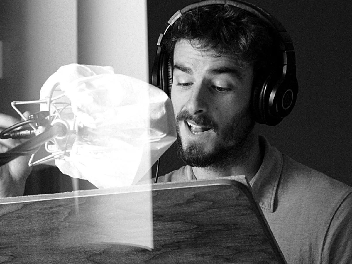 Luis Gustems locutando frente al micrófono en su estudio